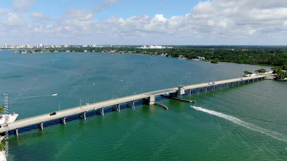 Aerial view of open street bridge crossing ocean with small boat and linking Island Bay and Sarasota, Florida, USA Aerial view of open street bridge crossing ocean with small boat and linking Island Bay and Sarasota, Florida, USA