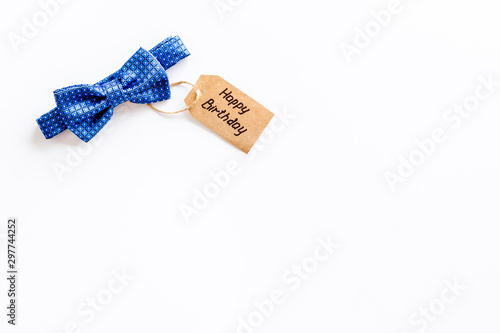 Men's birthday concept. Happy birthday text and bow tie on white background top view space for text photo