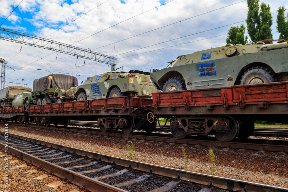 Cargo train carrying military vehicles on railway flat wagons Cargo train carrying military vehicles on railway flat wagons