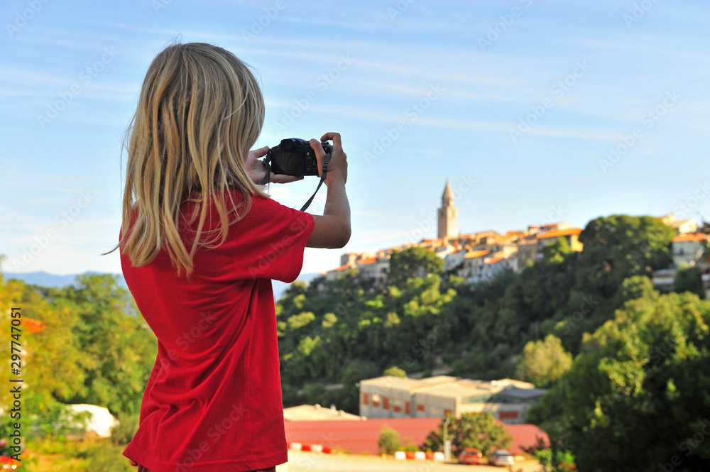 Little traveller taking a shot of Vrbnik town, Croatia Little traveller taking a shot of Vrbnik town, Croatia