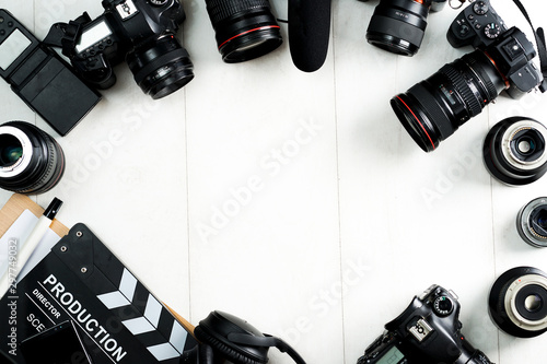 Camping or adventure trip scenery concept. Backpack, boots, belt, thermos and camera on wooden background captured from above (flat lay). Layout with free text (copy) space.