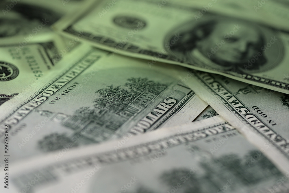 One hundred dollar bills on a dark surface close-up. Toned money background One hundred dollar bills on a dark surface close-up. Toned money background