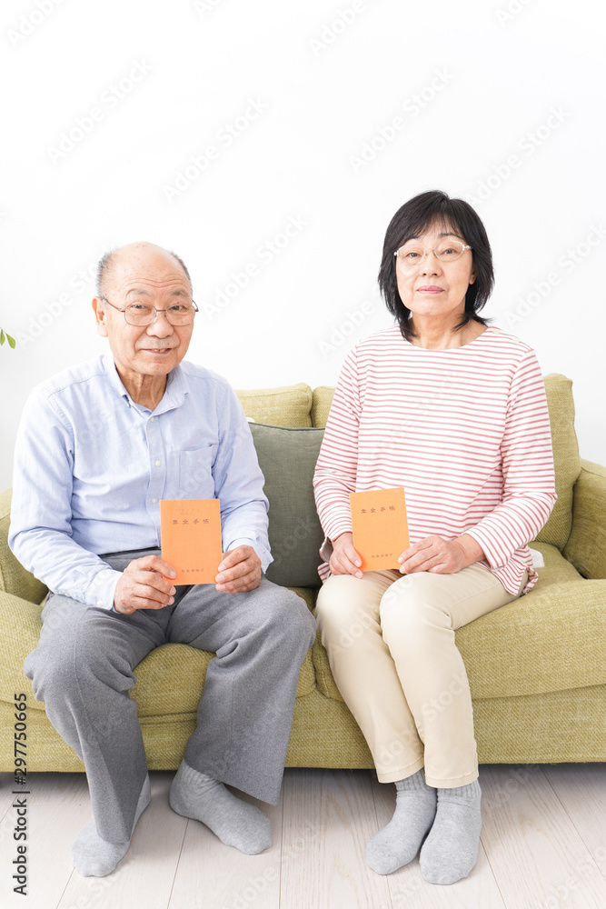 年金手帳を持つ高齢の夫婦 年金手帳を持つ高齢の夫婦