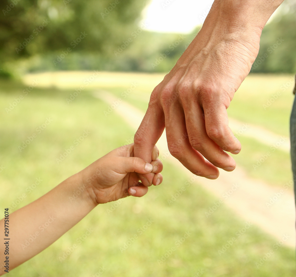 parent holds the hand of a small child parent holds the hand of a small child