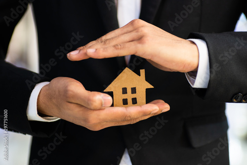 businessman holds a house in his hand; business concept