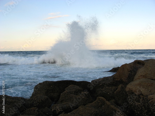 Waves make a huge splash on hitting a rock.