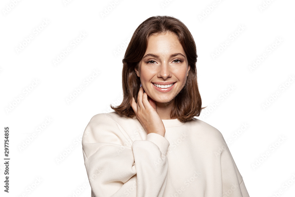 Beautiful dark-haired young woman with shine of the skin, cute smile in light beige blouse isolated on a white background. Beautiful dark-haired young woman with shine of the skin, cute smile in light beige blouse isolated on a white background.