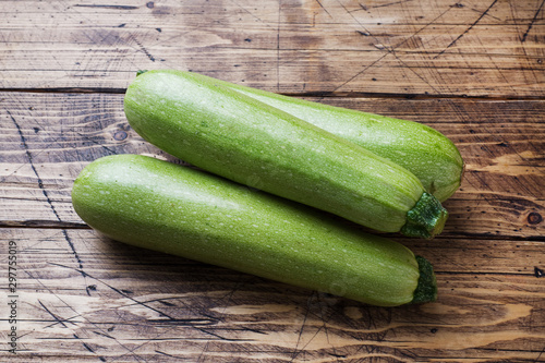 Fresh raw zucchini ready to eat on wooden background with copy space.