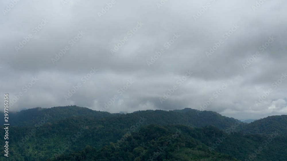 Hyperlapse video of rain clouds forming above mountain forest. (Aerial time lapse) 