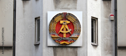 National emblem of East Germany (DDR) on a wall in Berlin near Checkpoint Charlie, Germany - August 2015