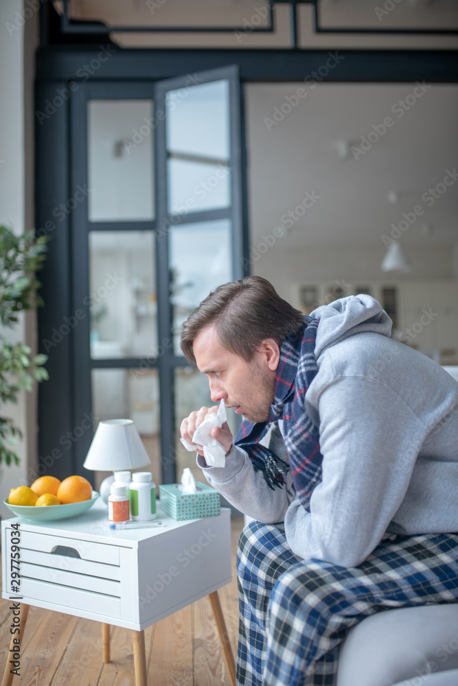 Man wearing warm clothing feeling bad after catching cold Man wearing warm clothing feeling bad after catching cold