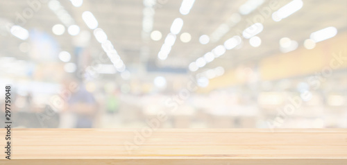 Foto Empty wood table top with supermarket grocery store blurred defocused background