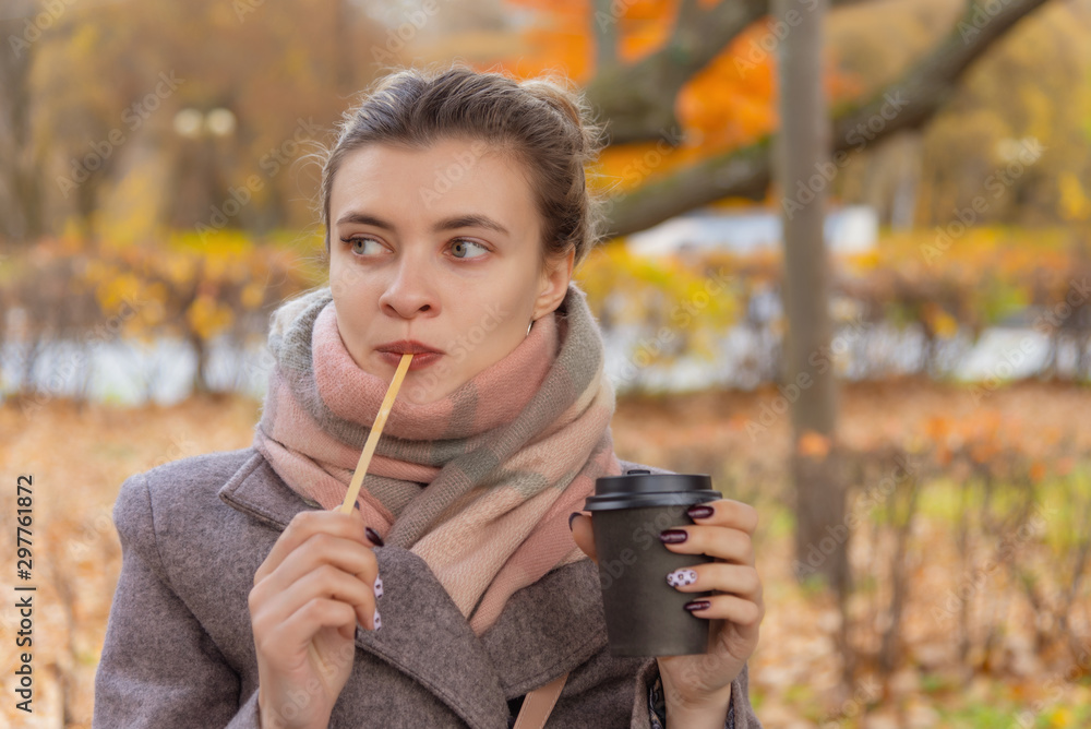 Young attractive woman holding a paper cup with coffee in her hands Young attractive woman holding a paper cup with coffee in her hands