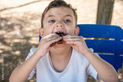 Littile arabic boy enjoying eating chocolate by him self