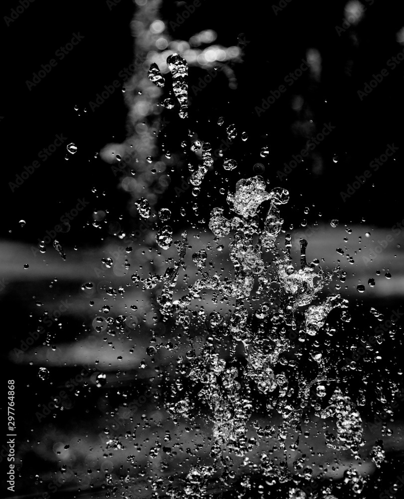 drops of water with splashes on a black background - obrazy, fototapety, plakaty 