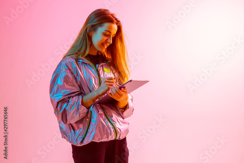 Modern Girl with laptop, tablet computer. Free creativity. A young blogger makes a Home office. Colored Neon light. photo