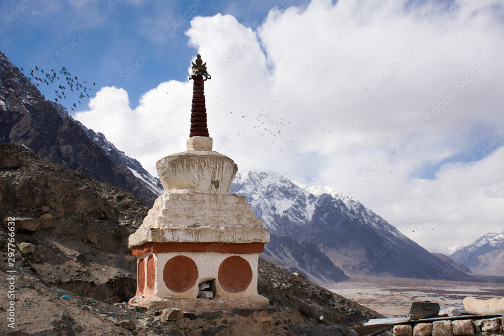 Stupa or chedi in Maitreya Buddha statue and Diskit Monastery or Deskit Gompa perched against the hills at nubra valley village at Leh Ladakh city in Jammu and Kashmir, India