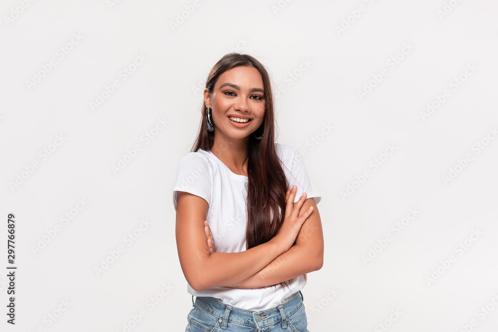 Pretty african-american teenager in a white tee and blue jeans smiling standing isolated over white background. Pretty african-american teenager in a white tee and blue jeans smiling standing isolated over white background.