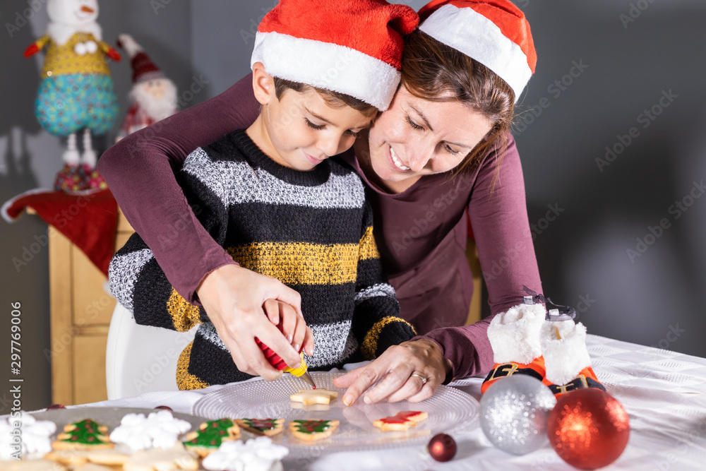 Mother and son decotating cookies on Christmas time