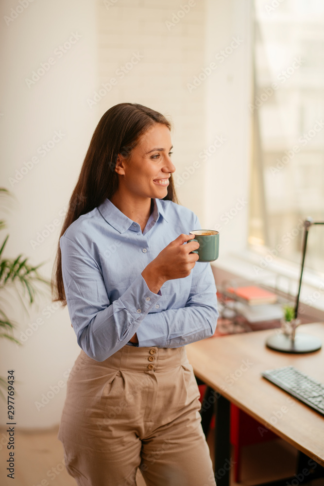 Young businesswoman drinking coffee in office Young businesswoman drinking coffee in office