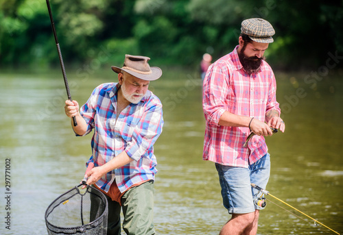 Mad Mans Hobby. Fly Fishing Time. hobby. two happy fisherman with fishing rod and net. hunting tourism. father and son fishing. Big game fishing. friendship. Camping on the shore of lake