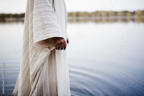 Fotografija Biblical scene - of Jesus Christ walking in the water with a blurred background
