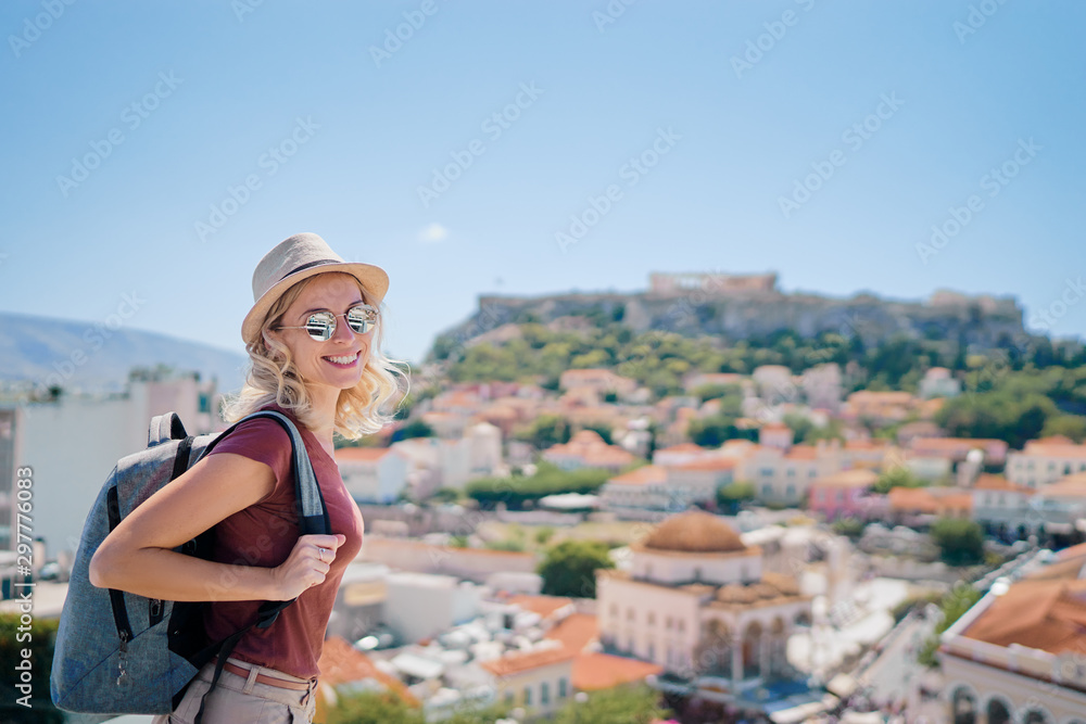 Enjoying vacation in Greece. Young traveling woman with rucksack enjoying view of Athens city and Acropolis.