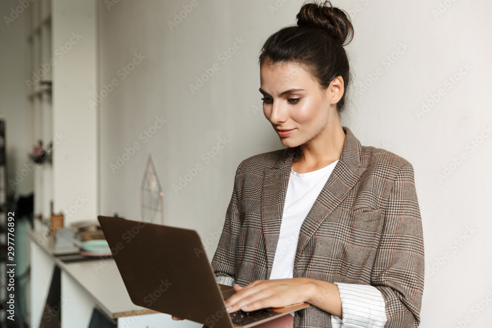 Business woman indoors at home using laptop computer. Business woman indoors at home using laptop computer.