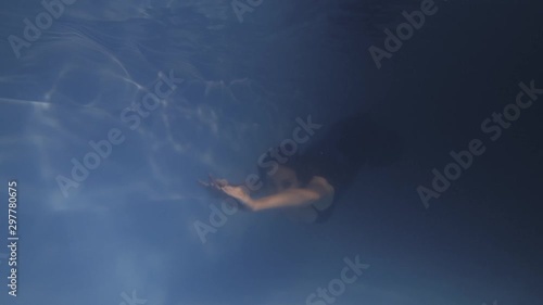 Wallpaper Mural Fit woman in blue dress is diving and swimming underwater in the pool, 4k Torontodigital.ca