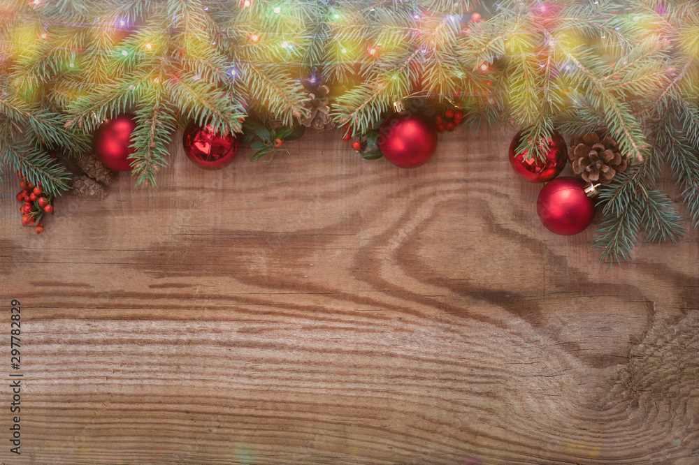 Background for Christmas design. Stylish design of bright red ball ornaments and green pine branches set on textured dark wood background, nice writing space for holiday themed designs Background for Christmas design. Stylish design of bright red ball ornaments and green pine branches set on textured dark wood background, nice writing space for holiday themed designs
