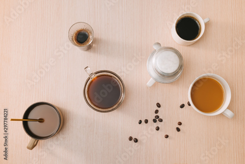 Cups of coffee with coffee beans and vietnamese Phin filter on wooden background