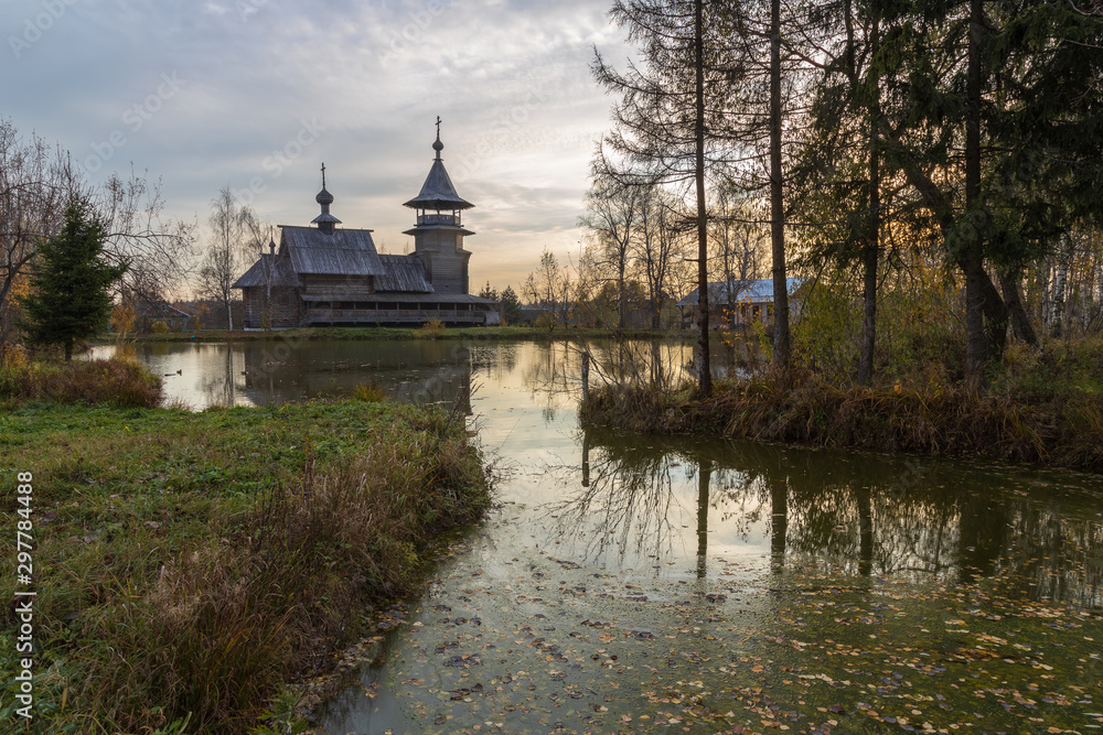 Wooden orthodox church of the Annunciation and its reflection in the lake on an autumn day. Moscow region, Sergiev Posad district. The Blagoveshheniye village