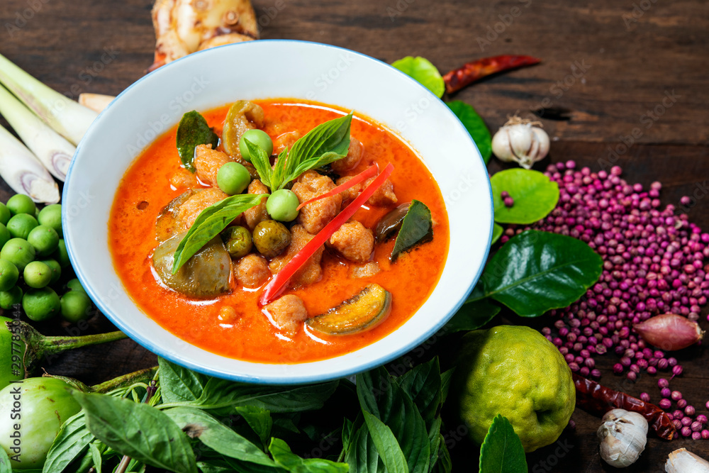 Popula Thai food Red Curry Chicken with ingredients on wood background. ,Thai name kang pad, spicy curry Popula Thai food Red Curry Chicken with ingredients on wood background. ,Thai name kang pad, spicy curry