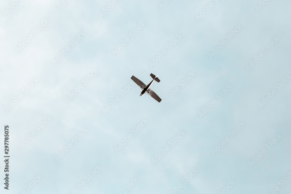 Naklejka premium Small propeller aircraft flying in a blue sky