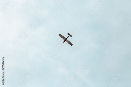 Small propeller aircraft flying in a blue sky