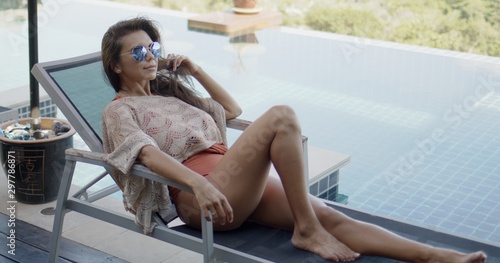 Woman relaxing on deckchair beside swimming pool enjoying vacation time © Dash