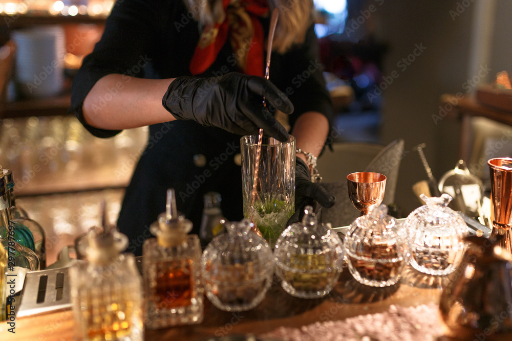 Cropped view of female hands, preparing a cocktail, a mojito. The barman is preparing a drink. Horizontal view.
