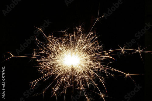 Closeup view of bright burning sparkler on a black background