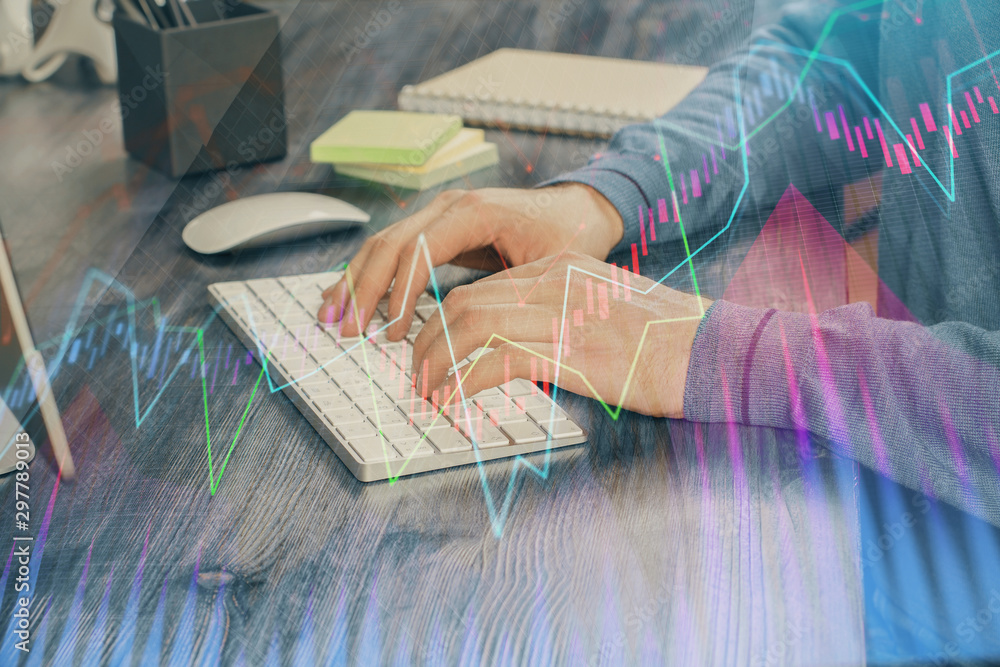 Stock graph with businessman typing on computer in office on background. Concept of analysis. Double exposure.