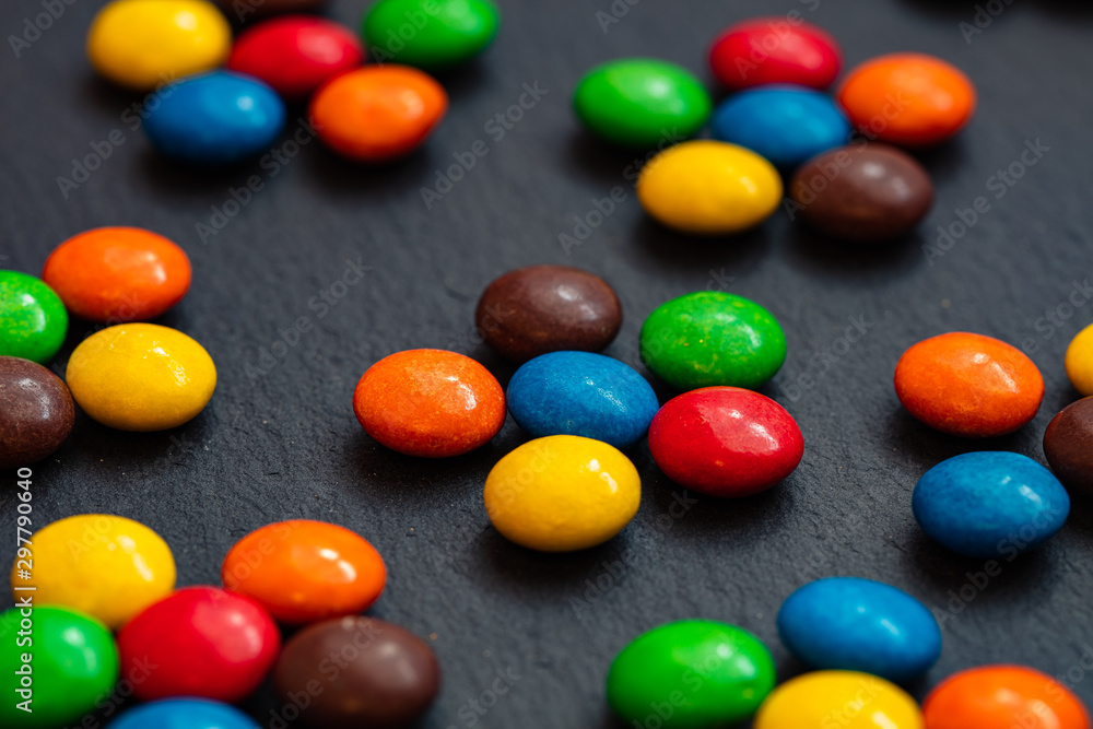colorful chocolate buttons isolated on a black background colorful chocolate buttons isolated on a black background