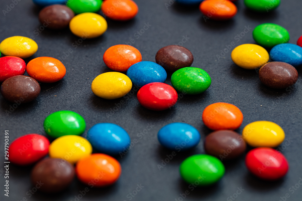 colorful chocolate buttons isolated on a black background colorful chocolate buttons isolated on a black background