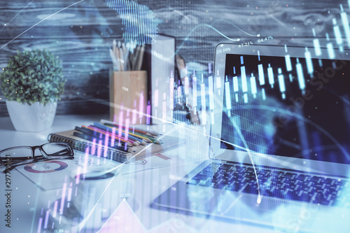 Stock market graph on background with desk and personal computer. Double exposure. Concept of financial analysis.