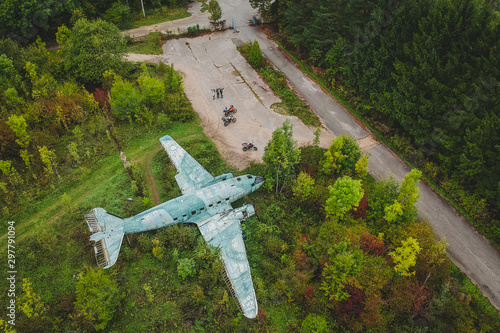 A drone shot of an abandoned airplane and some motorcyclists. photo