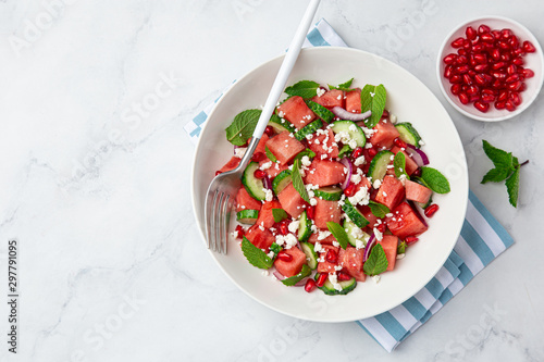 Watermelon, cucumber, feta and mint salad in white bowl