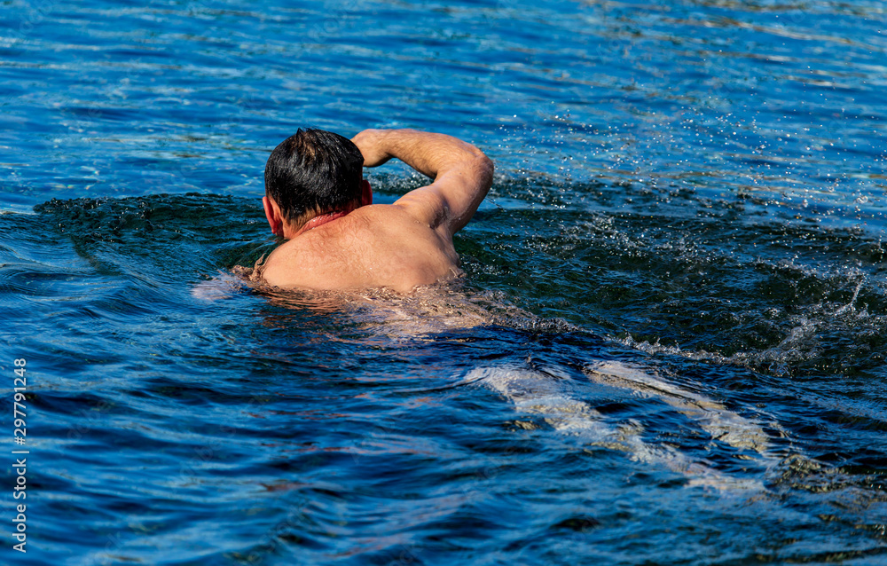 A man swims on the surface of a reservoir