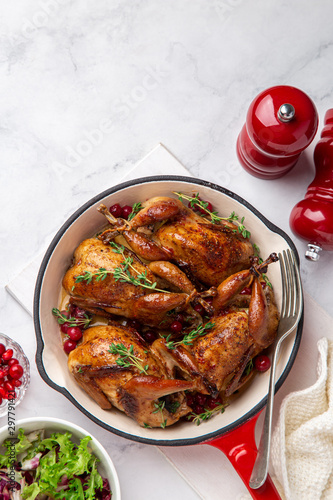 Roasted quail with cranberry and thyme on pan photo