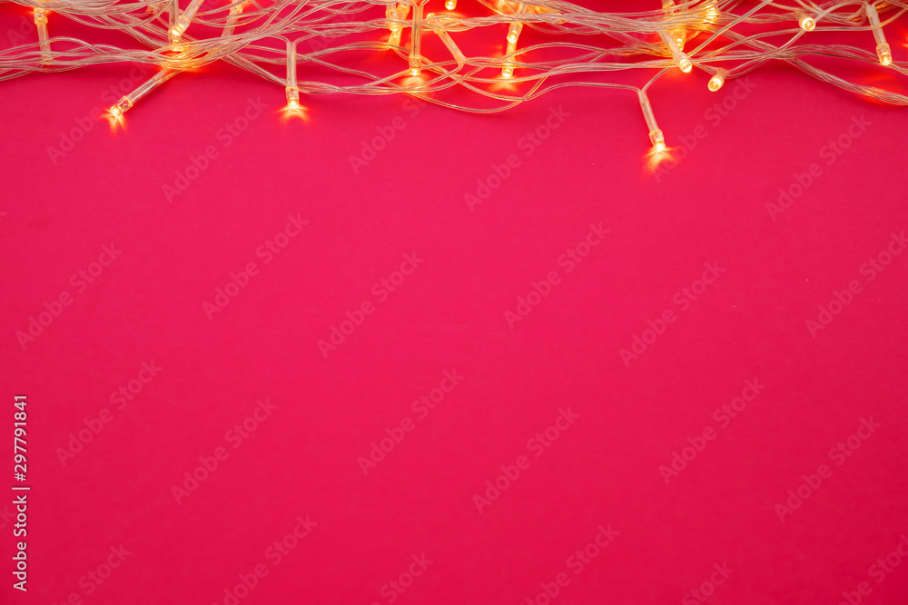 Illuminated garland lights on bright pink background