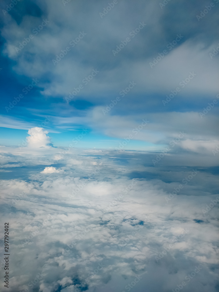 Fototapeta premium Sunrise above clouds from airplane window. Bright blue sky top horizontal view copyspace. Travelling concept View of the engine.