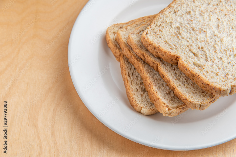Sliced bread on white dish, wood background Sliced bread on white dish, wood background
