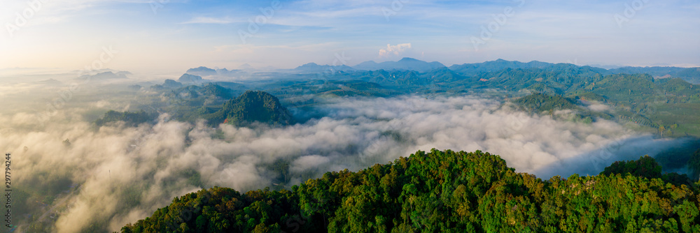 Aerial view of mountains with cloud cover mountain at sunrise and blue sky in Surat Thani Province, Thailand.